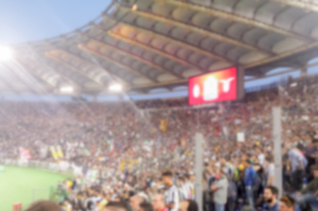 Defocused background with supporters in the stadium for football match. Intentionally blurred post production for bokeh effectの写真素材