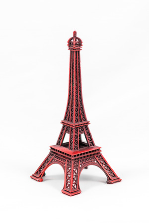 Close up shot of a red miniature model of the Eiffel Tower isolated on a white backgroundの写真素材