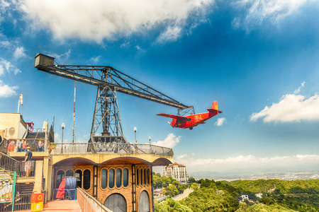 BARCELONA - AUGUST 12: The red airplane carousel attraction at Tibidabo Amusement Park, Barcelona, Catalonia, Spain on August 12, 2017. The park is among the oldest in the world still functioningのeditorial素材