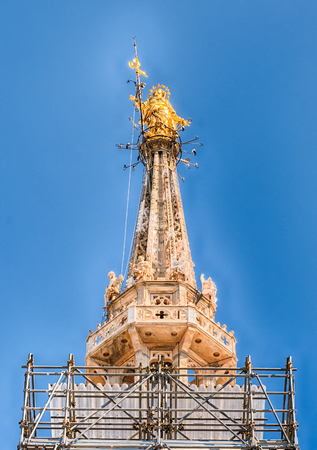 Golden Madonna statue, aka Madonnina, on the rooftop of the gothic Cathedral, the most iconic landmark of Milan, Italyのeditorial素材