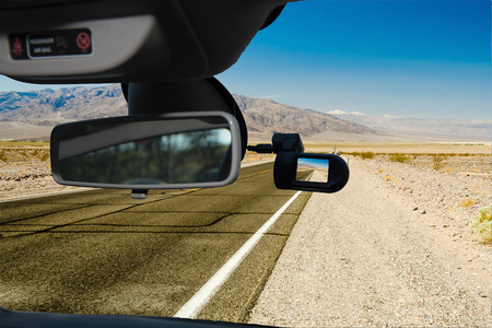 Looking through a dashcam car camera installed on a windshield with view of a hot desert road in Death Valley National Park, California, USAの写真素材