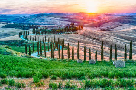 ASCIANO, ITALY - JUNE 23: Scenic sunset over one of the most iconic landscapes with cypresses in Tuscany, near the town of Asciano, province of Siena, Italy, as seen on June 23, 2019のeditorial素材