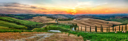 ASCIANO, ITALY - JUNE 23: Scenic sunset over one of the most iconic landscapes with cypresses in Tuscany, near the town of Asciano, province of Siena, Italy, as seen on June 23, 2019のeditorial素材