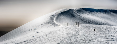 Scenic winter landscape with snow covered mountains, located in Campocatino, touristic ski town in the Central Apennines, Italyの写真素材