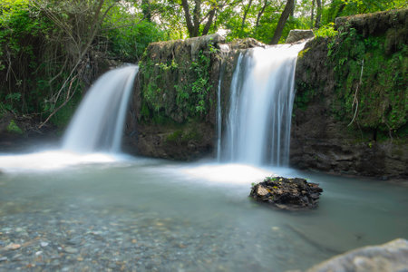 Long exposure of a small waterfall in the woods, idyllic nature scenery located in Fiumefreddo Bruzio, province of Cosenza, Italyの写真素材
