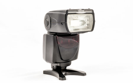 Oblique view of a black unbranded external flash unit for DSLR camera
