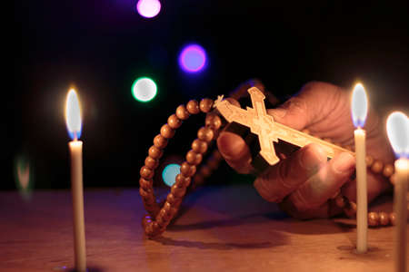 cross with rosary in handの写真素材