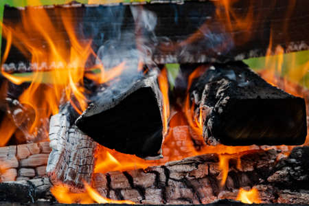 Burning wood in a barbecue grill. Open flames. Cooking outdoors.の写真素材