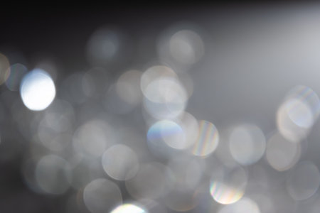 Abstract bokeh effect background in grey colours with rainbow rays.の写真素材