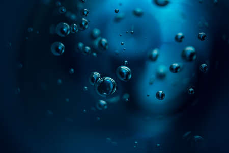 Abstract background of dark blue color bubbles in liquid.