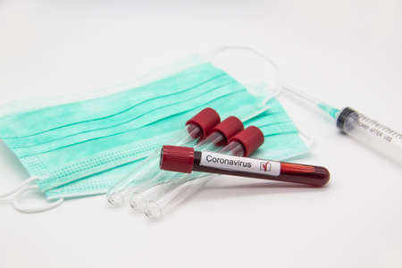 Coronavirus blood test concept. A test tubes with Coronavirus positive blood over laboratory desk....