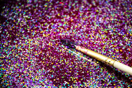 the abstract background with sparkles, glitters and painting brush. Paint brush with glitter in red liquidの写真素材