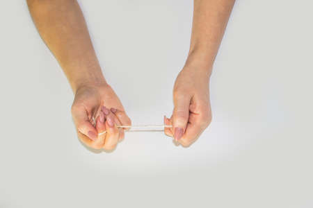 Women's hands hold the rope in the light background. Female hands pull the rope between each other. Hands pull the rope.の写真素材