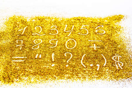 a composition with numbers and symbol on beautiful gold glitter. Background and texture of gold glitter. Luxury gold glitter sparkle shining texture backgroundの写真素材
