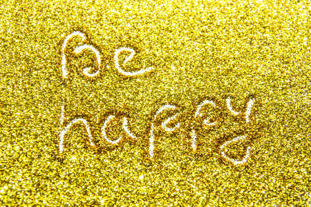 a composition with written a words be happy on beautiful gold glitter. Background and texture of gold glitter. Luxury gold glitter sparkle shining texture backgroundの写真素材