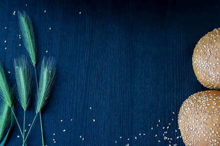 Buns with sesame seeds on the wood background. Composition over the wood background with copy space...
