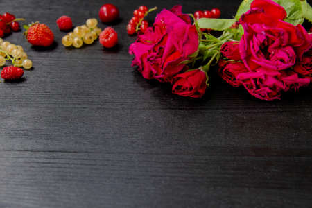 Beautiful roses with leaves and berry on the dark wood background. Great conposition with roses and...