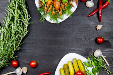 Composition with crayfish, rosemary, pepper, garlic, tomatoes, dill, parsley, pickled cucumbers. Cooking food background with free space for text. Top view with copy spaceの写真素材