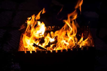 Fire on a dark background. Fire from firewood close up. Flaming burning sparks close-up, fire patterns. Red and orange Infernal glow of fire in the dark.の写真素材