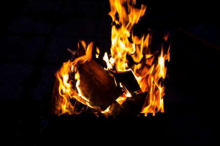 Fire on a dark background. Fire from firewood close up. Flaming burning sparks close-up, fire patterns. Red and orange Infernal glow of fire in the dark.の写真素材