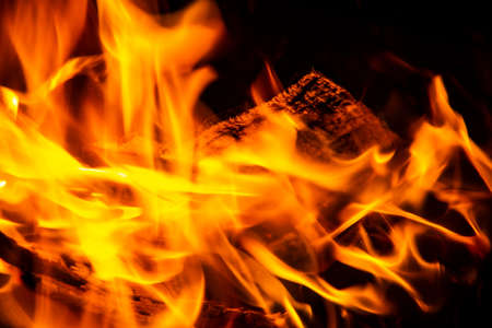 Fire on a dark background. Fire from firewood close up. Flaming burning sparks close-up, fire...