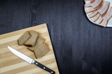 Ukrainian traditional meal. Slices of bread with kitchen knife and slices of salted pork lardon the...