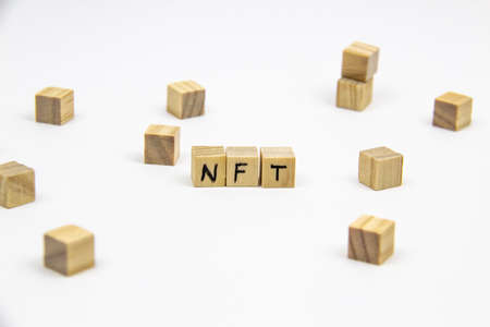 Word NFT (non fungible token) written on the wood cubes on white background. Non-fungible tokens concept NFT.の写真素材