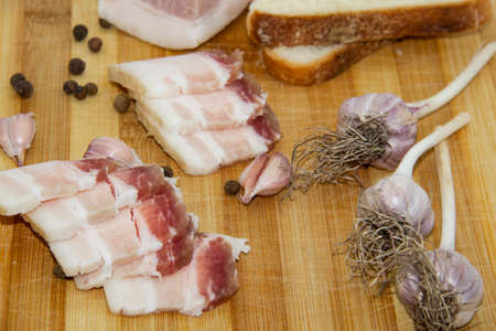 Ukrainian traditional food concept with white bread. Ukrainian raw lard with peppercorn and garlic,...