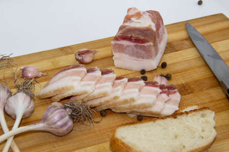 Ukrainian traditional food concept with white bread. Ukrainian raw lard with peppercorn and garlic,...