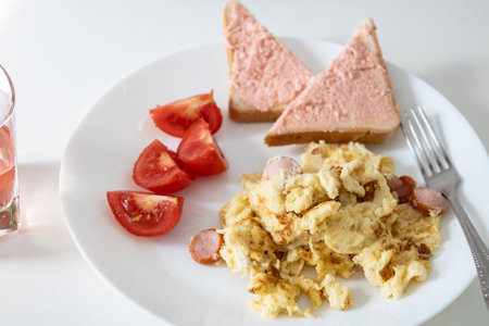Delicious food - omelette with sausage, tomato slices, slices of bread with capelin caviar on a...