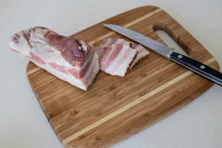 Very tasty pieces of salo. Raw bacon or salo on wooden board. Sliced salted pork lard (salo). Food concept.の写真素材