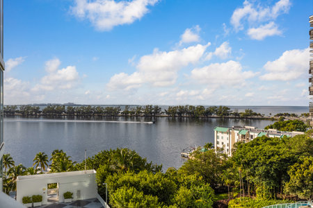 Beautiful view from the balcony towards the bay of Miami, bridge with trees, horizon, blue sky, tropical vegetation, sailing boat, pierの写真素材