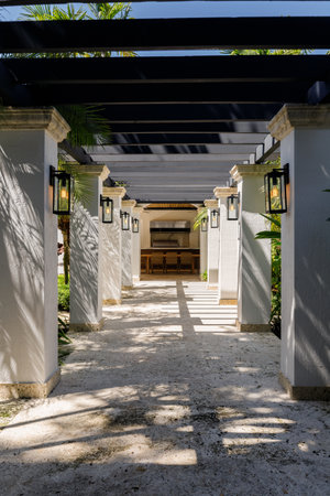 Colonial corridor of columns with lights and tropical plants, summer kitchen in the backgroundの写真素材