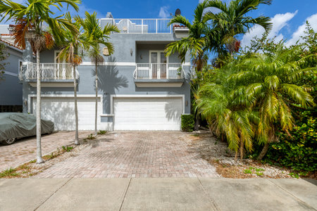 Front of luxury colonial house with tropical plants, garage, balcony, tilesの写真素材