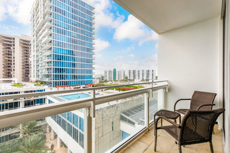 View from balcony to the sea and beach of Miami, with modern buildings, tropical plants and blue skyの写真素材