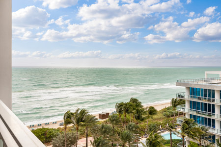 View from balcony to the sea and beach of Miami, with modern buildings, tropical plants and blue skyの写真素材