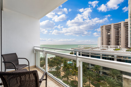 View from balcony to the sea and beach of Miami, with modern buildings, tropical plants and blue skyの写真素材
