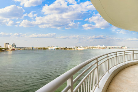 View from balcony on Brickell Key island in Miami, modern buildings and towers, boats, bridges, sea, outdoor chairs, white railingの写真素材