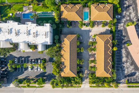 Aerial drone shot of suburban neighborhood in Pompano Beach, with bushes, trees, tiled roofs, parking areas, palms, trees, canals.の写真素材