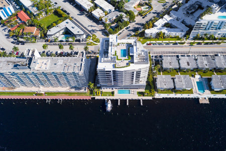 Aerial drone shot of the Central Beach neighborhood in Fort Lauderdale, where we see abundant tropical vegetation, modern buildings, rivers, boats, houses facing the water, blue skyの写真素材