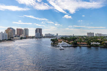 Aerial drone shot of the Central Beach neighborhood in Fort Lauderdale, where we see abundant tropical vegetation, modern buildings, rivers, boats, houses facing the water, blue skyの写真素材