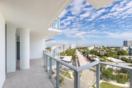 Balcony shot in the ADAGIO building overlooking the Central Beach neighborhood in Fort Lauderdale, where we see abundant tropical vegetation, modern buildings, blue sky with cloudsの写真素材