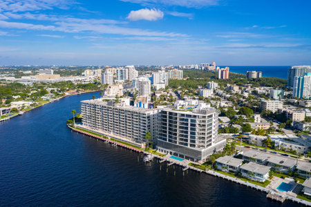 Aerial drone shot of the Central Beach neighborhood in Fort Lauderdale, where we see abundant tropical vegetation, modern buildings, rivers, boats, houses facing the water, blue skyの写真素材