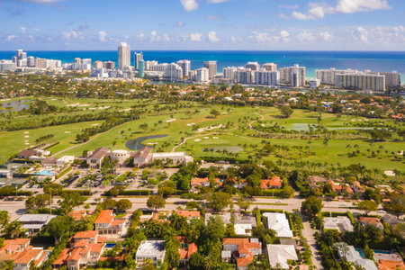 Drone aerial shot of La Gorce neighborhood in Miami Beach, golf course, tropical weather, towers and modern buildings, Biscayne bay, tropical plants and modern houses aroundの写真素材