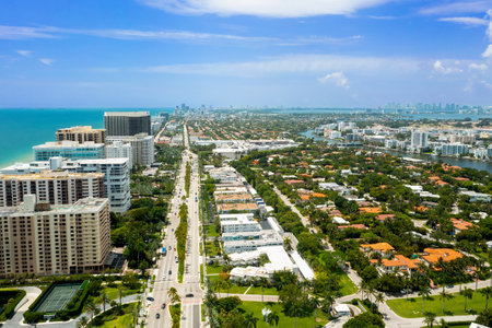 Aerial drone shot of Bal Harbor villa, condominiums, elegant houses, modern towers surrounded by tropical vegetation, summer weather, bay with boats and piers, turquoise sea and blの写真素材