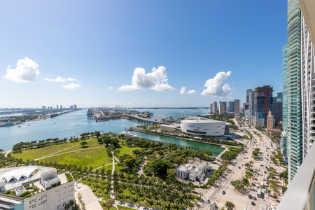 Aerial shot from the back of commercial area in Downtown Miami, parks, bridges, cars, brown buildings, museums, towers, piers and blue skyの写真素材