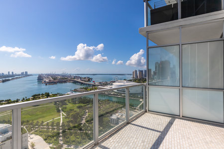 Aerial shot from the back of commercial area in Downtown Miami, parks, bridges, cars, brown buildings, museums, towers, piers and blue skyの写真素材