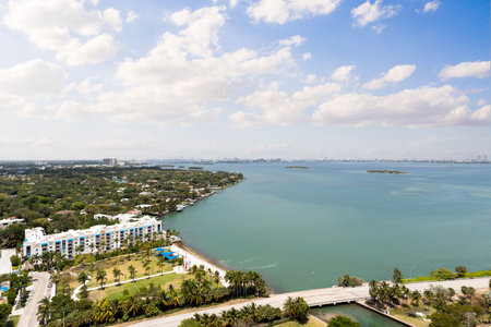 Aerial shot from balcony of suburb in Edgewater, view of Biscayne Bay, with large tropical vegetation around, modern houses and towers, commercial areas, summer weather, blue skyの写真素材