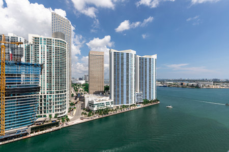 Aerial shot from a drone of the Brickell Key area, with a lot of towers and modern buildings, commercial urban landscape, surrounded by sea and canals, boats sailing, piers, bridgeの写真素材