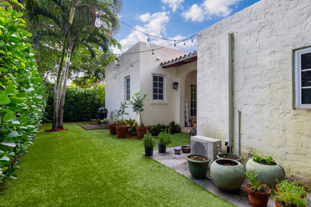 Backyard of a colonial-style house with a beautiful garden with several potted plants, hanging lamps, tiled roof, located in the Granada neighborhood in the city of Coral Gables, pの写真素材